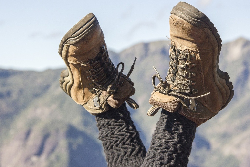 mountaineer woman with her legs crossed in the air wearing hiking boots in Rio de Janeiro.